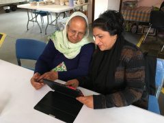 Advisory Group = Two women use a tablet computer