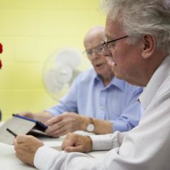 Men at Gatehouse Caring on tablets given to them by WaveLength